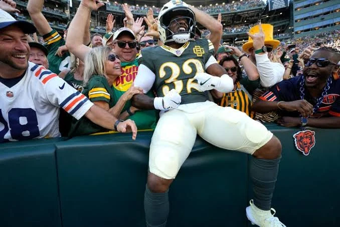 A Green Bay player celebrates with fans at Lambeau Field